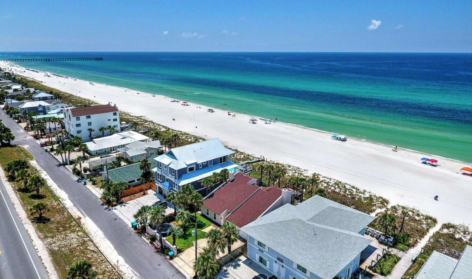 Tall white homes located on the left of screen
