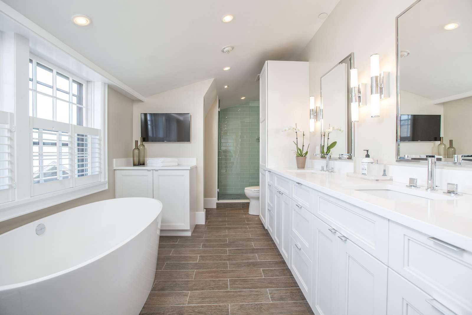 Master bathroom with dual vanity, tub, LED TV and elegant tiled shower