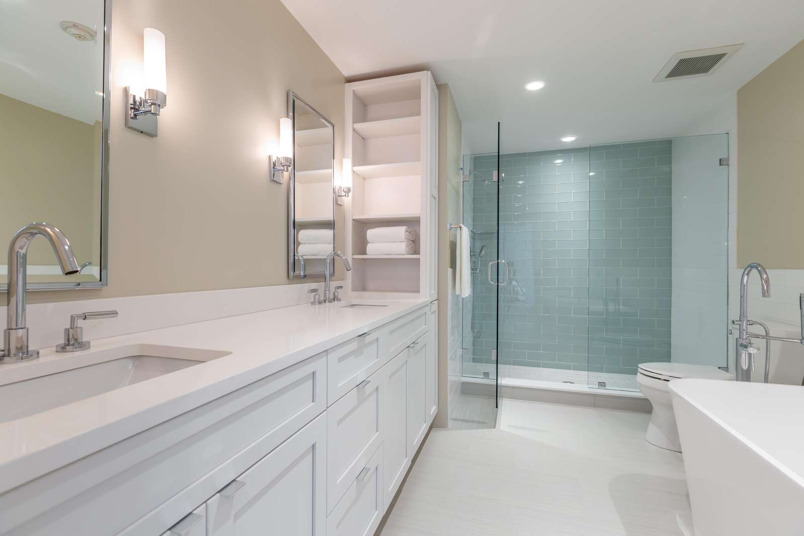 Master bathroom with dual vanity, tub, and tiled shower in 2 bedroom apartment