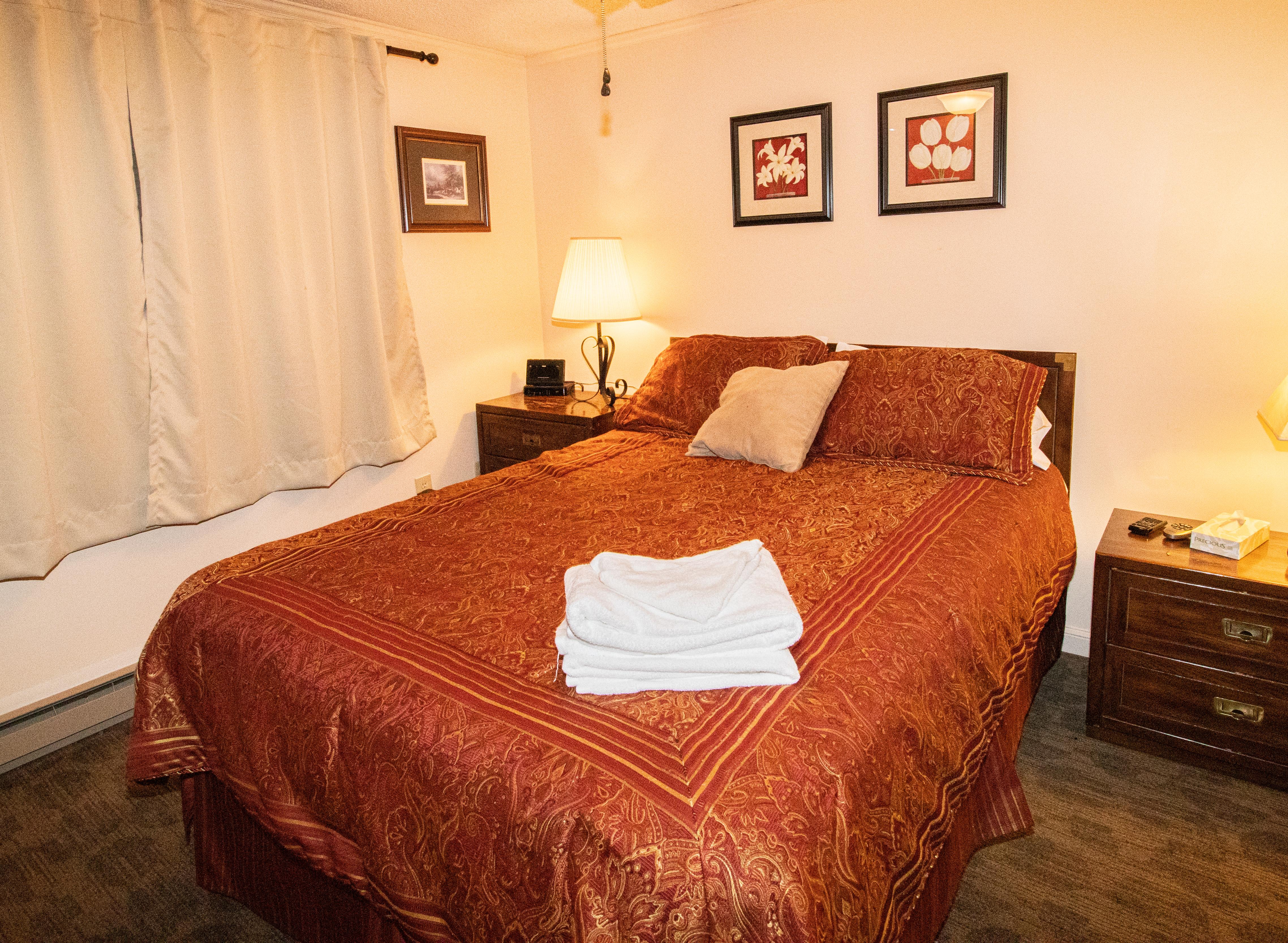 Queen-size bed with ceiling fan in bedroom