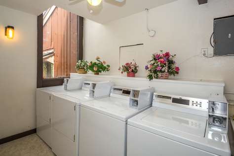 The public laundry room upstairs in the condominium building with coin operated machines.