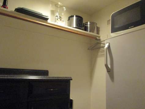 The walk-in closet behind the kitchen with refrigerator/freezer and microwave.
