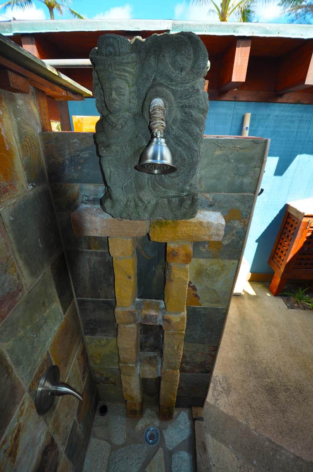 View of Indonesian stone carving of a woman with a water vessel used for the outdoor shower