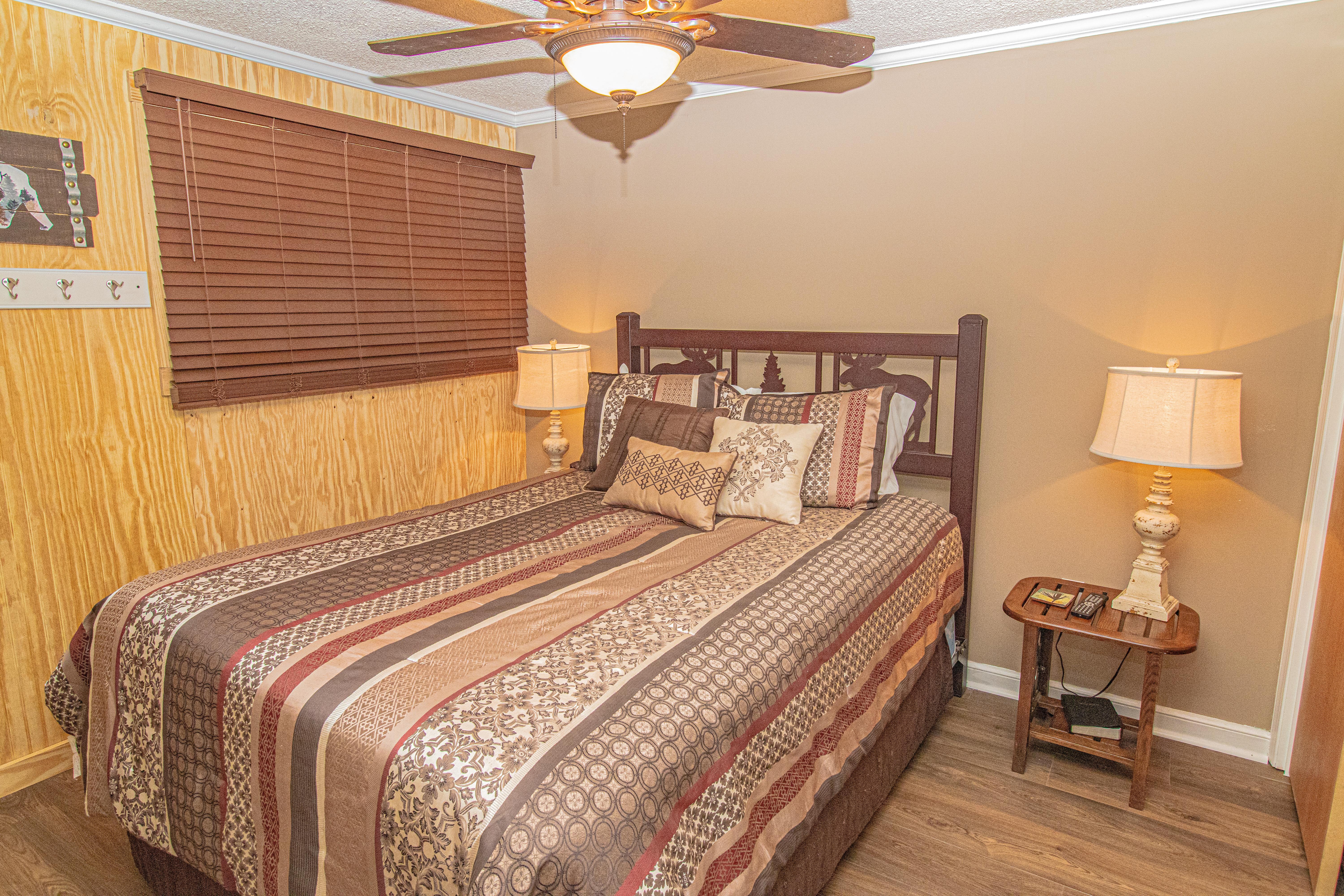 Second bedroom features queen-sized bed and wall-mounted TV