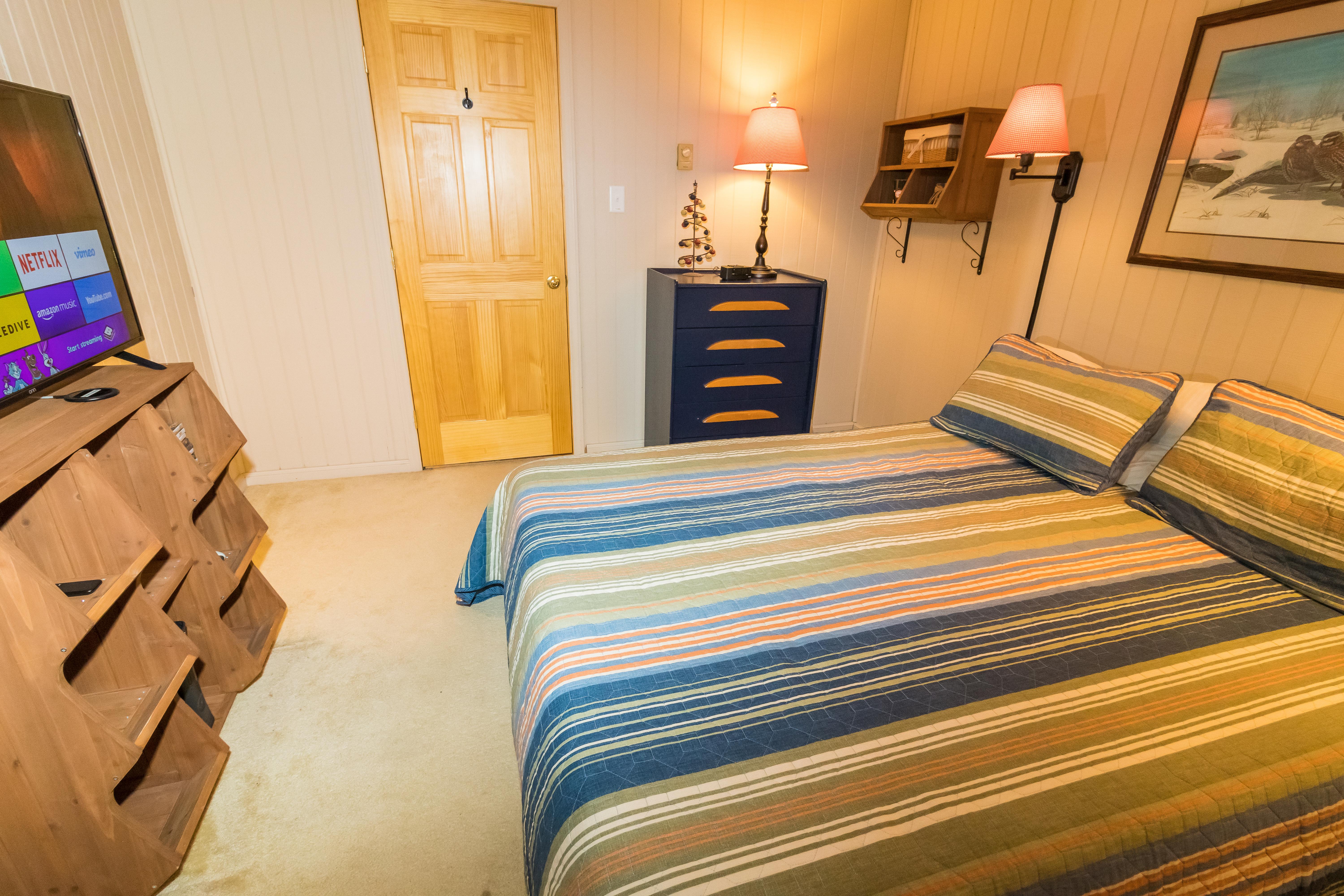 Full-sized bed in second bedroom; chest of drawers and closet for storage.