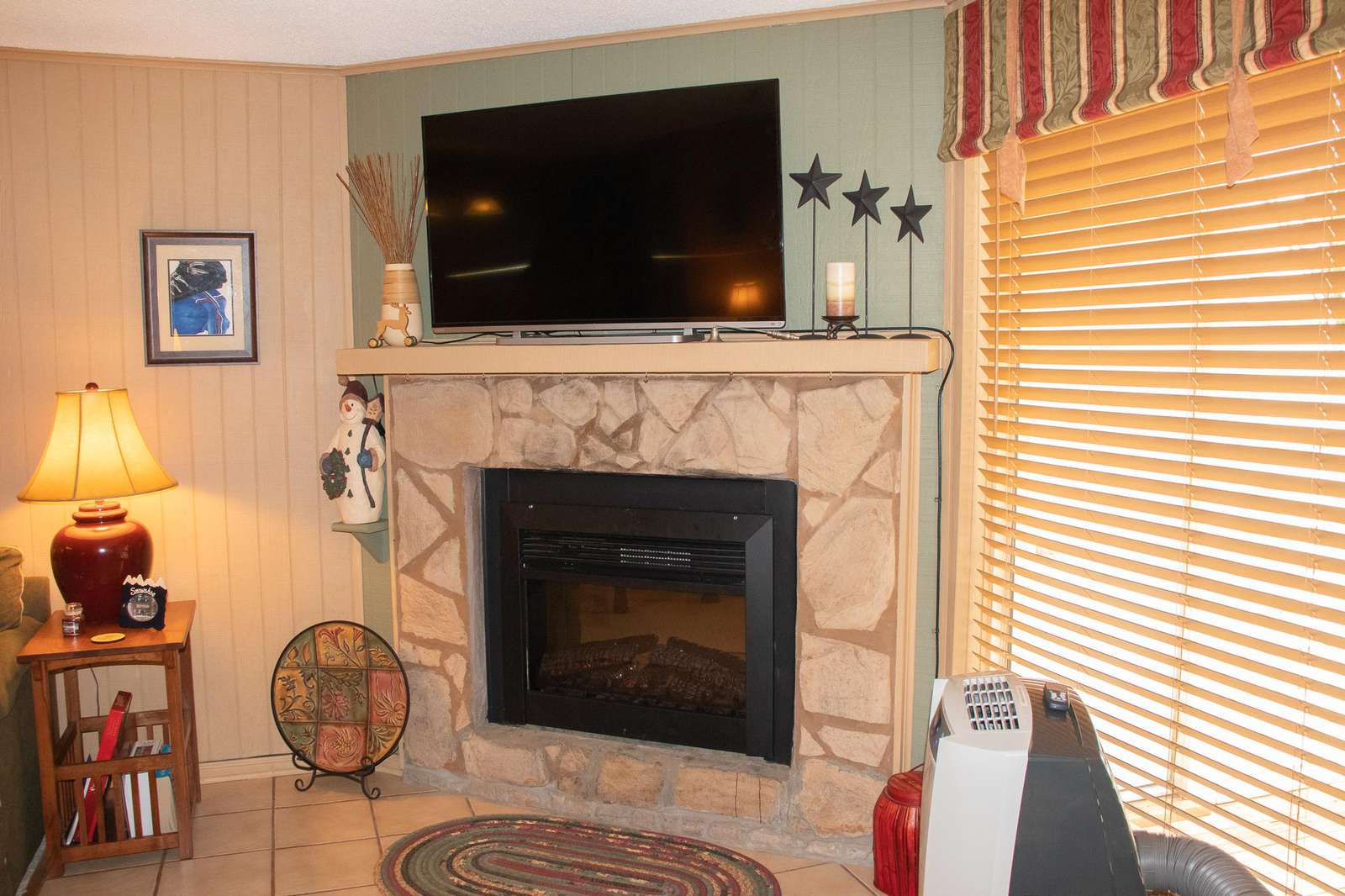 Electric fireplace with large-screen TV mounted above; HD channels and Google Chromecast