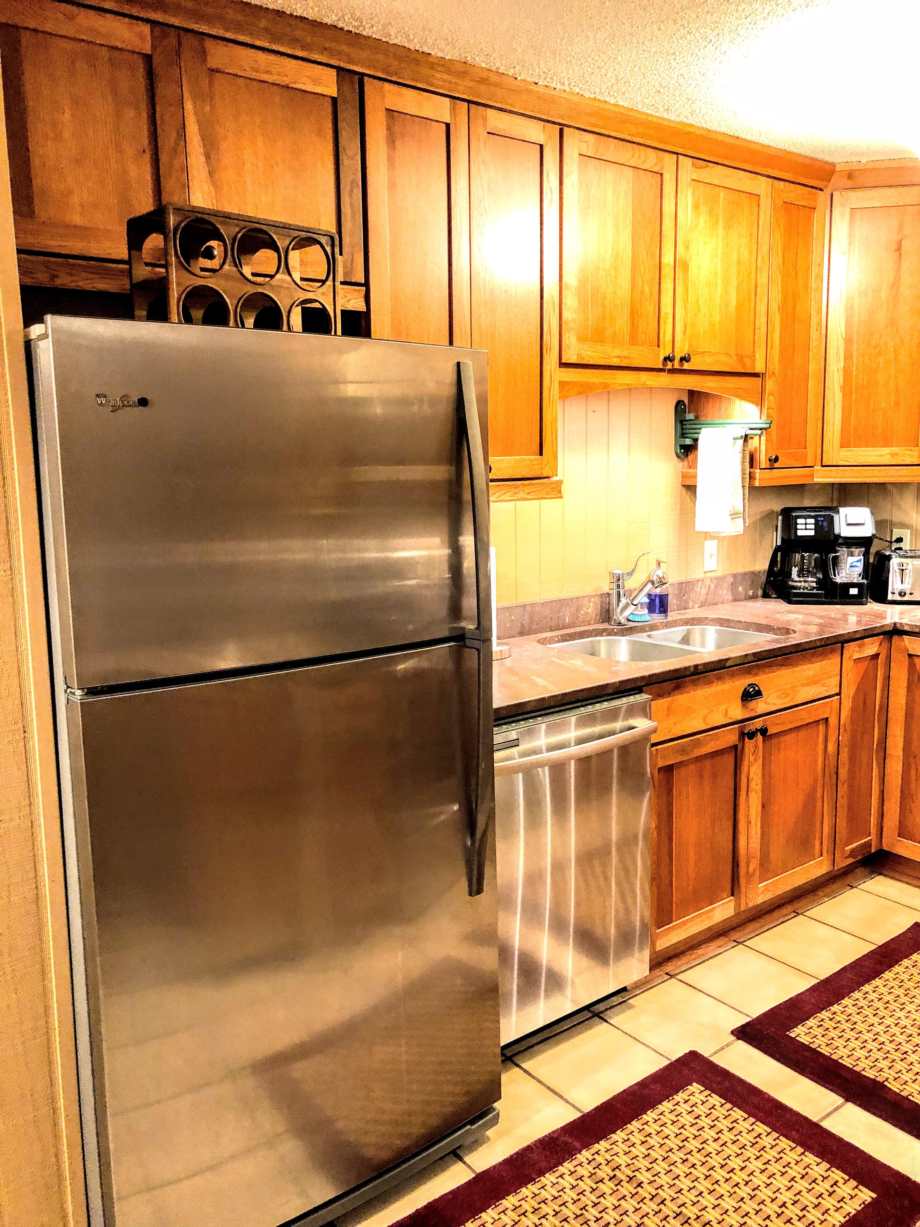 Full-sized stainless steel fridge, full-sized oven and electric cook top, toaster oven, and dishwasher