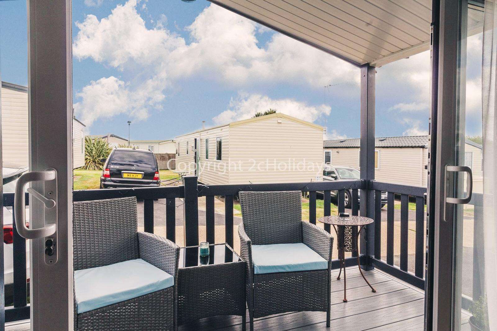 Beautiful outside, sheltered, enclosed decking with rattan furniture!