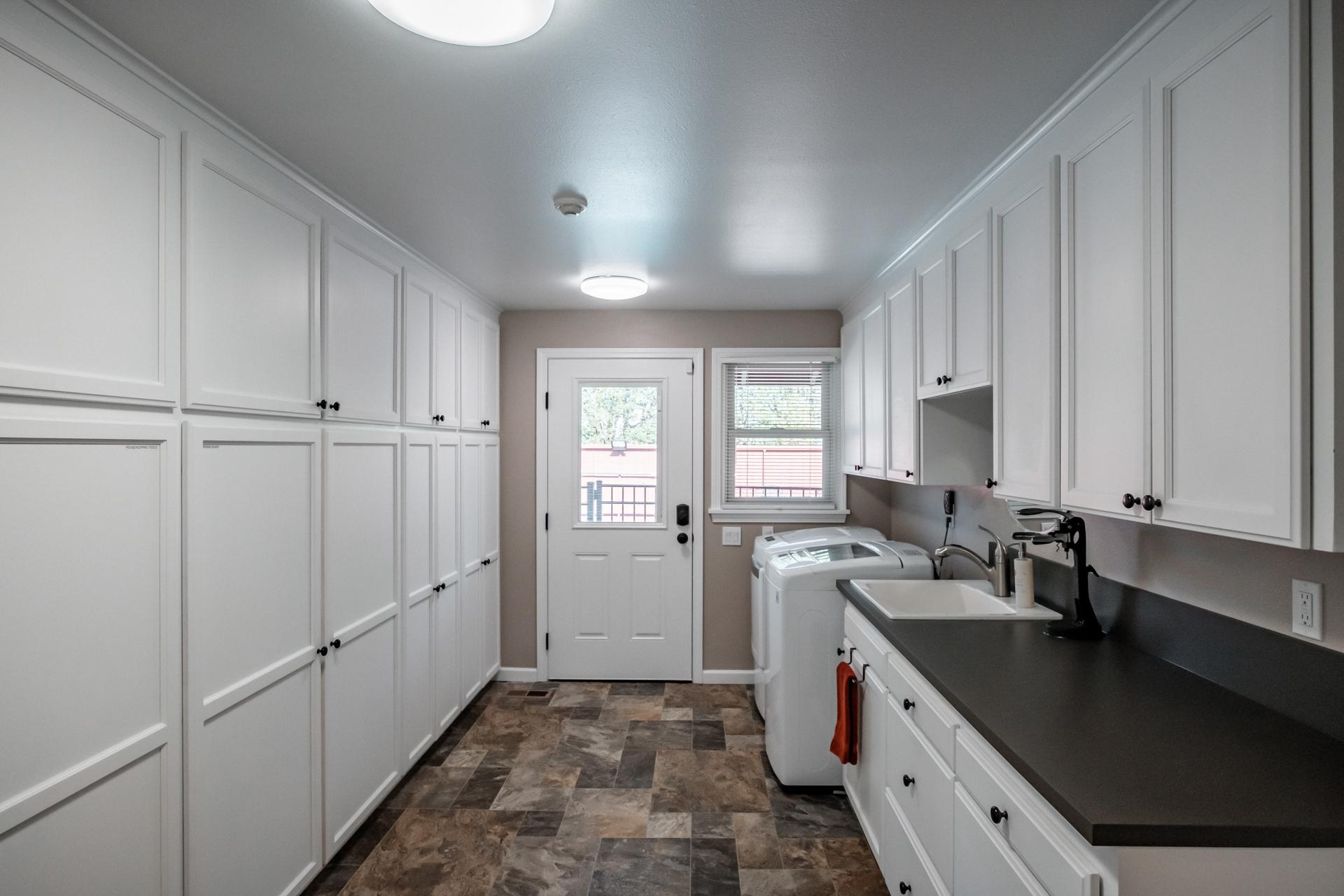 Utility Room with washer, dryer, utility sink and storage.
