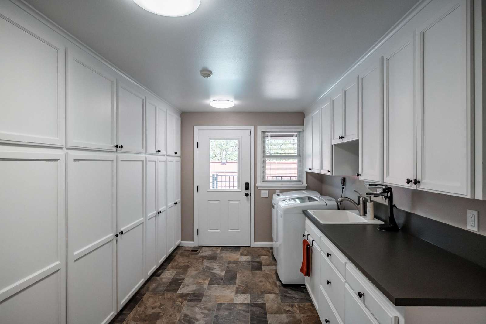 Utility Room with washer, dryer, utility sink and storage.