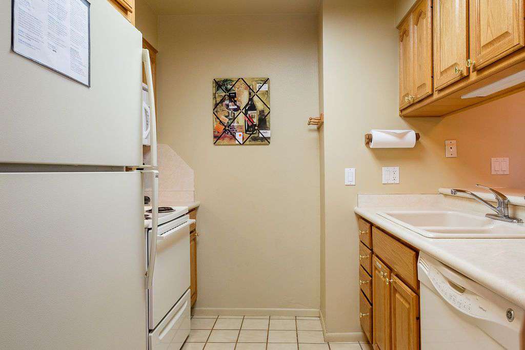 Kitchen straight view including fridge and sink
