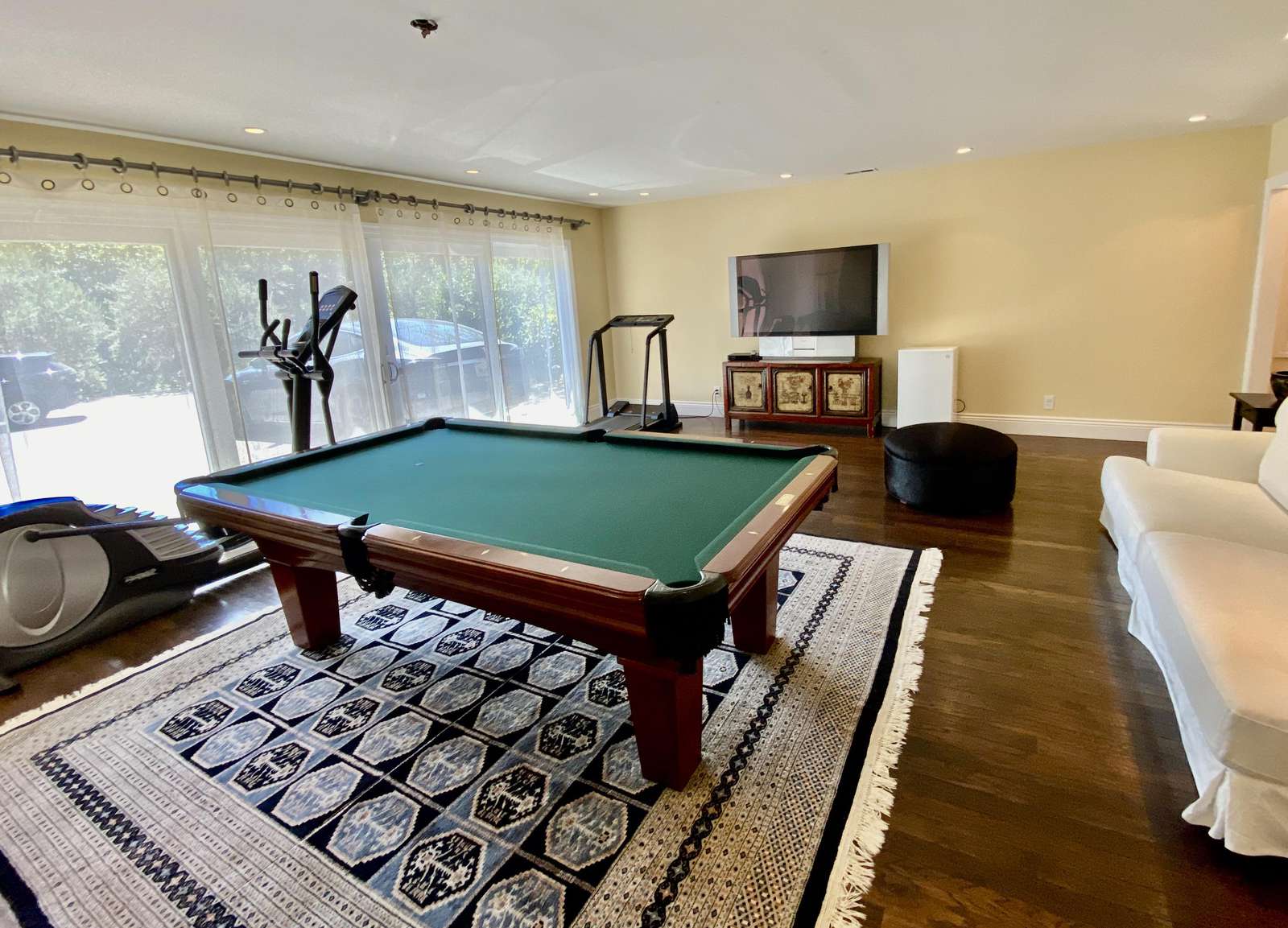 Lower level game room w/ pool table, large TV and exercise equipment