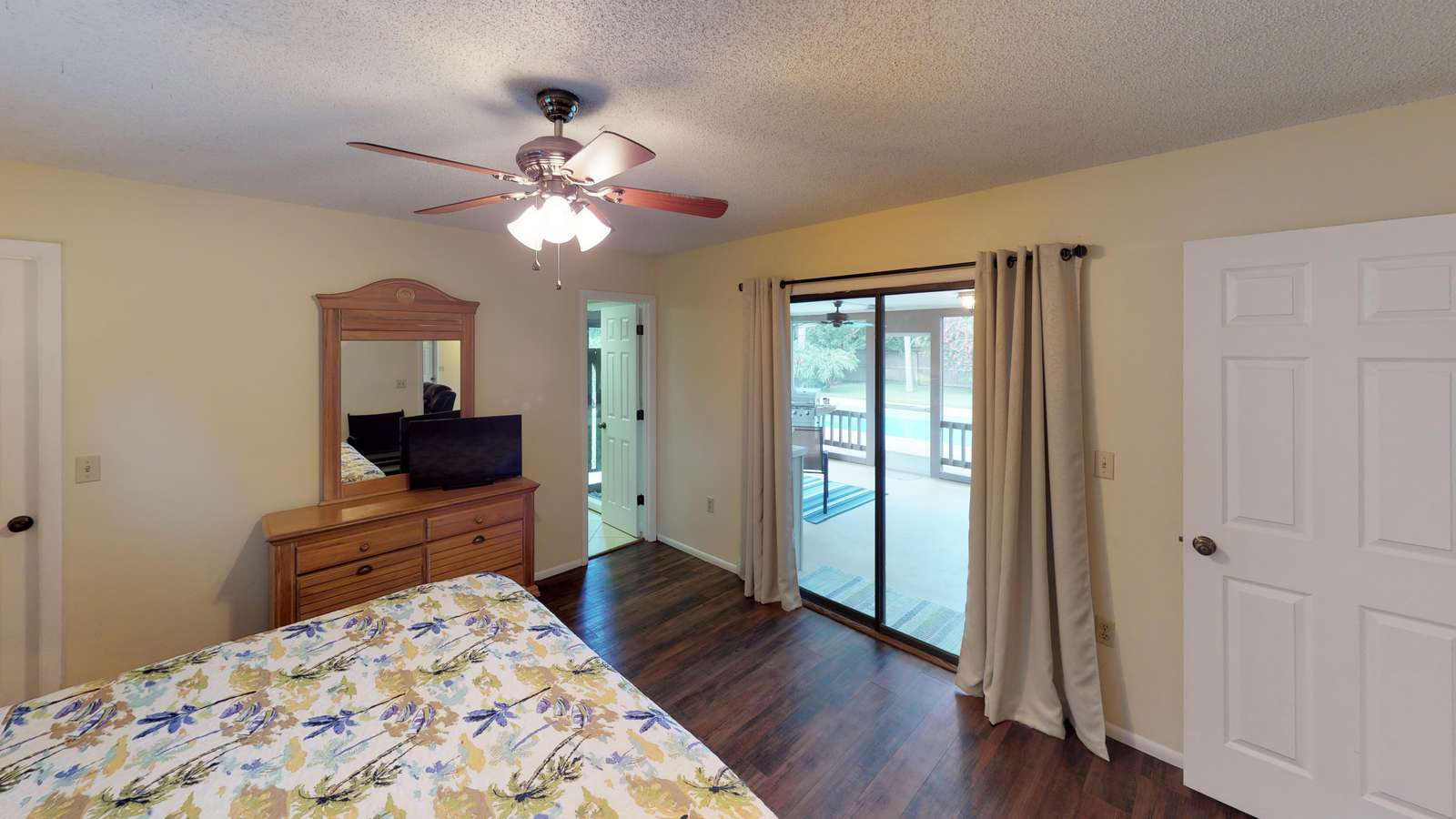 Primary Bedroom with king bed, private bathroom and view to lanai/pool