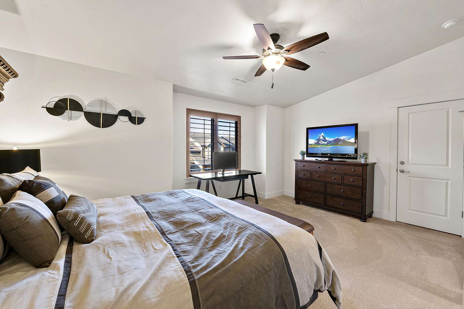 Master bedroom with window views and dresser